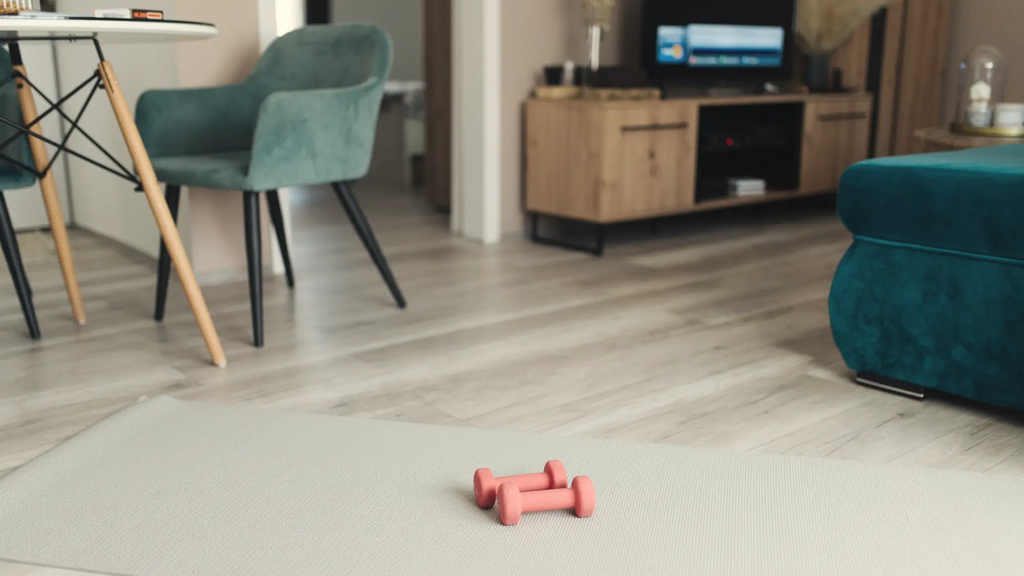 A calm room with an exercise mat, light dumbbells and soft daylight