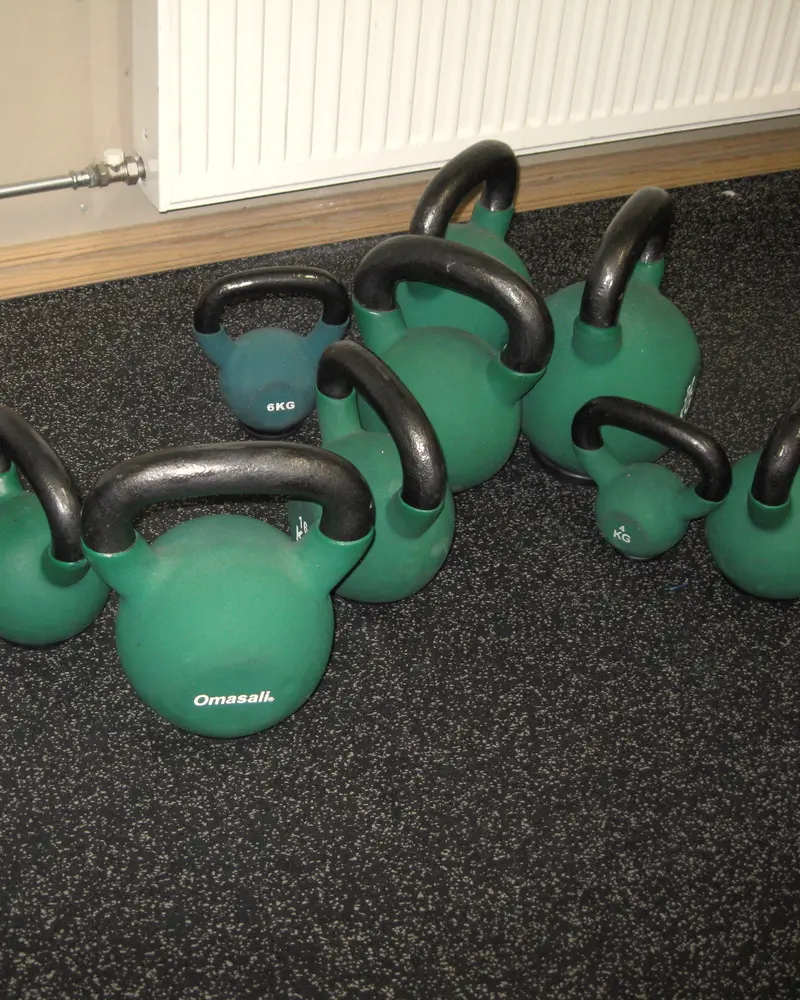 A group of green kettlebells on a studio floor